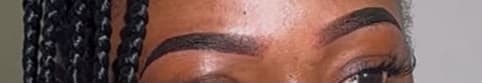 Sharply defined, tinted brows with a clean arch and crisp tail